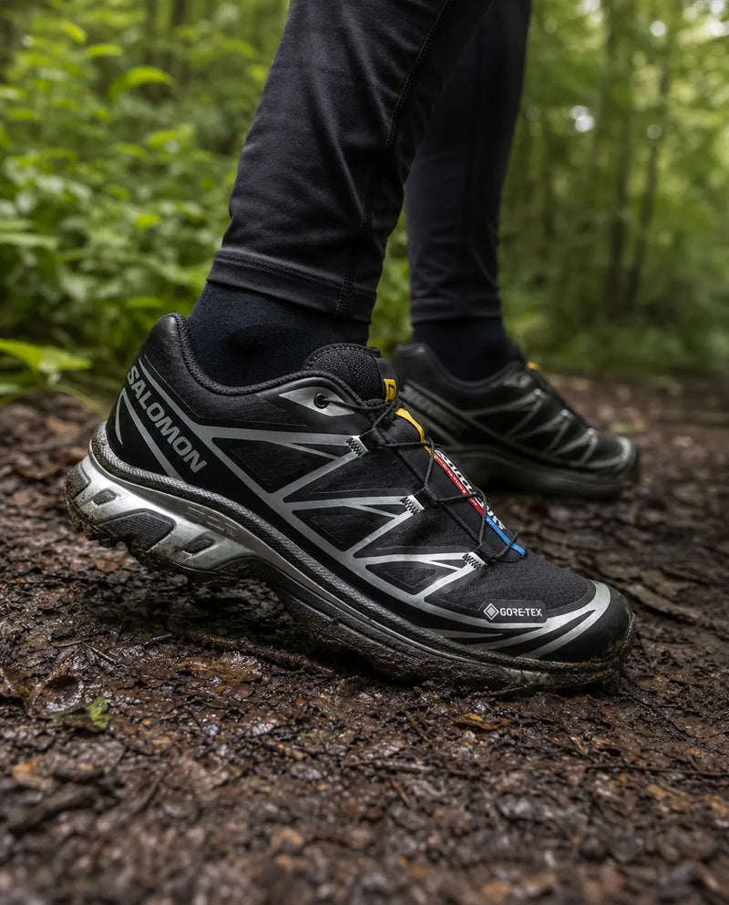 Sneakers Salomon XT6 couleur noire pour homme et femme utilisé par un randonneur